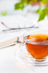 cups of tea with book on wooden table