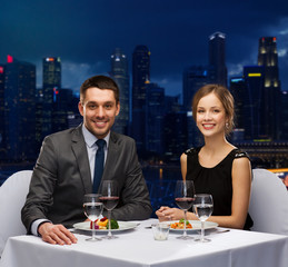 smiling couple eating main course at restaurant
