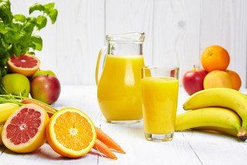 Full glass and jug of banana juice and bananas