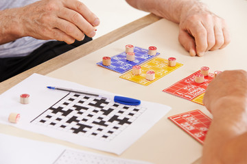 Alte Hände von Senioren beim Bingo spielen