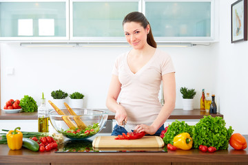 Young woman in the kitchen prepare salad
