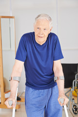 Alter Mann mit Krücken beim Rehasport