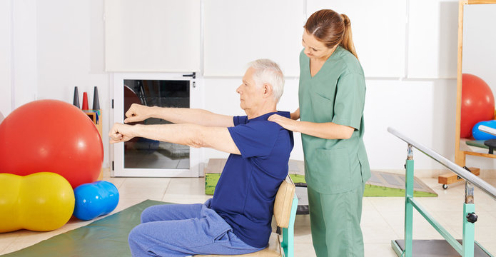 Senior beim Rehasport macht R&uuml;cken&uuml;bung