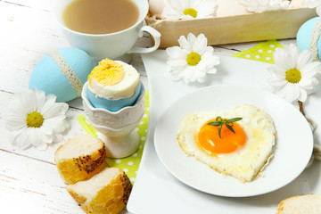 Easter table setting with flowers and eggs on old wooden table