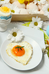 Easter table setting with flowers and eggs on old wooden table