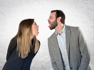 Couple sticking out her tongue over white background