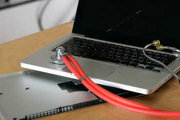 kaputter Laptop und Stethoskop