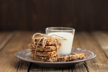 Granola bars with glass of milk on wooden background