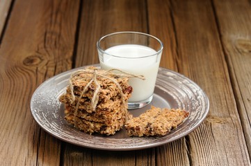 Granola bars with glass of milk on wooden background