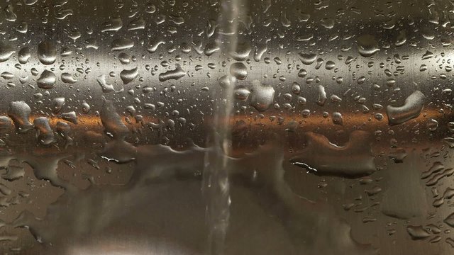 Water dripping in stainless steel kitchen sink