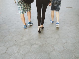 piernas de tres paseantes en la calle