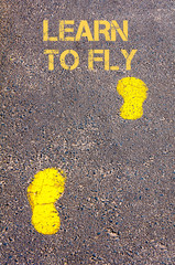 Yellow footsteps on sidewalk towards Learn to fly message