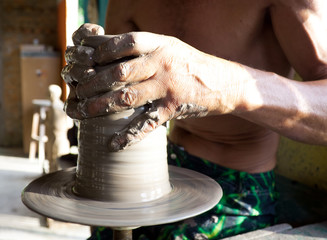 hands of a potter manufactures clay pot