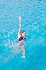 Obraz na płótnie Canvas Woman in goggles swimming back crawl style
