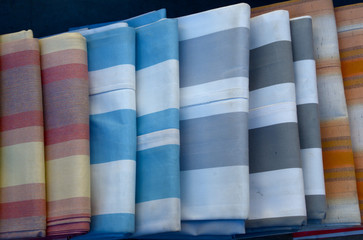 carelessly stacked striped fabric in different colors