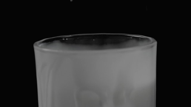 Strawberry falling into the milk in slow motion