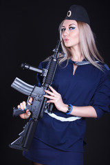 Fototapeta premium Woman in a navy uniform with an assault rifle