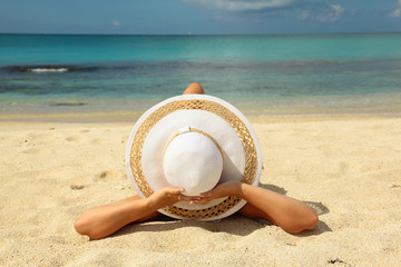 Fototapeta na wymiar Young woman lying on sandy beach
