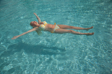 woman floating in a swimming pool