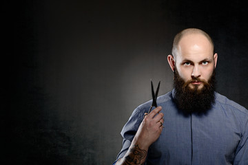 Bald man with a beard wearing a blue shir