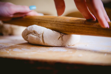 emale hand rolled dough on a pizza
