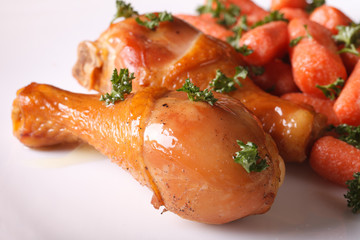 Roasted chicken legs and glazed carrots close-up horizontal