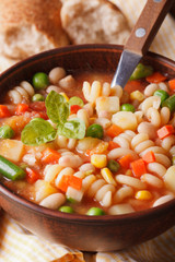 Italian minestrone soup in a bowl macro. Vertical
