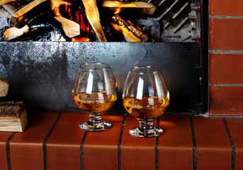 Two tanks of cognac on the old brick fireplace with a bright fir