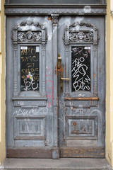 Old wooden door in Prague, written in graffiti