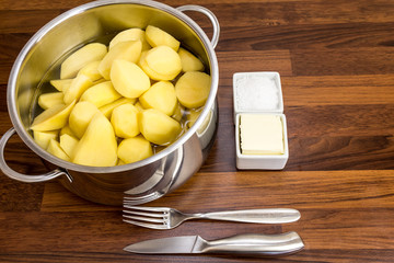 Rohe, geschälte Kartoffeln in einem Topf mit Wasser, mit Butter und Salz IV