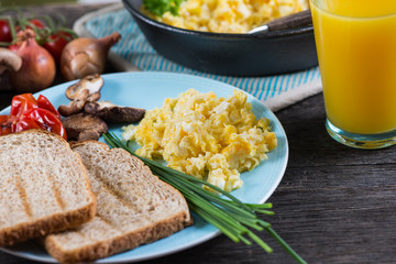 eating healthy breakfast, scrambled egg with chives and fresh ju