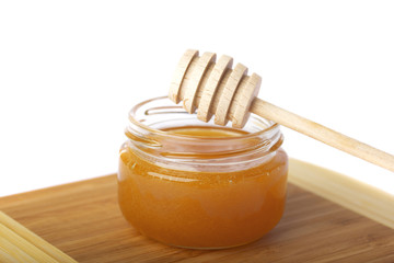 Деревянная ложка на стеклянной баночке с медом
