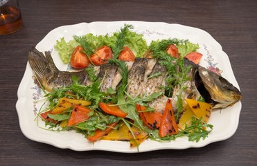 The baked carp with vegetables and spices