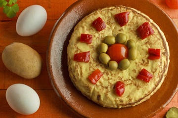 Spanish omelette on antique plate and ingredients