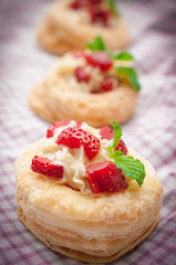 Strawberry Tart with Fresh Cream in Puff Pastry on wooden mat