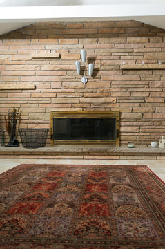 Masonry wall and brass fireplace in living room