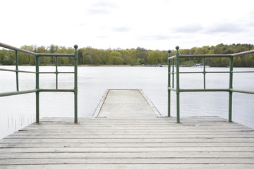 Naklejka premium Wood pier with iron railing by lake, Stockholm, Sweden.