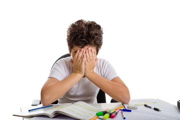 Tired boy hides his face on homework