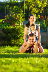 Happy young family having fun outdoors in summer. 