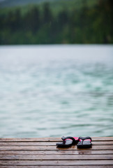 Flip flops on a Dock in front of a Turquoise Water Lake