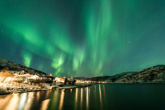 Northern Lights over village in Norway coast