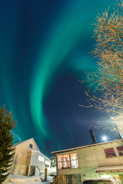 Aurora Borealis above suburbs and house in Norway