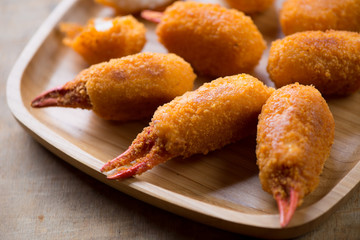 Bamboo tray with breaded crab claws, close-up, selective focus