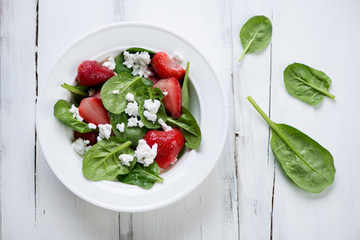 Salad with strawberries, spinach leaves and cheese, above view