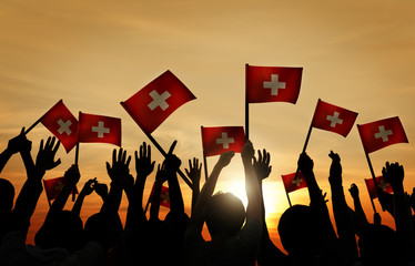 People Waving Switzerland Flags Back Lit Concept