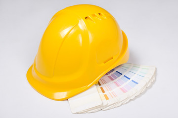 builder's yellow helmet and colorful palette over white