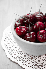 Fresh cherries in bowl on table