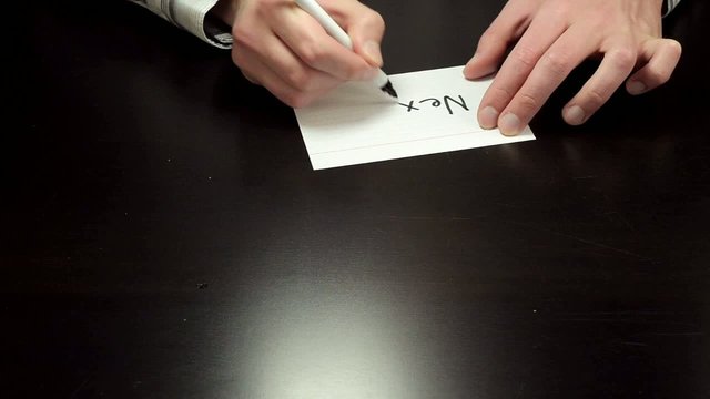 Hands draw the word Next