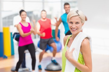 Fototapeta premium Portrait of happy woman holding towel at gym