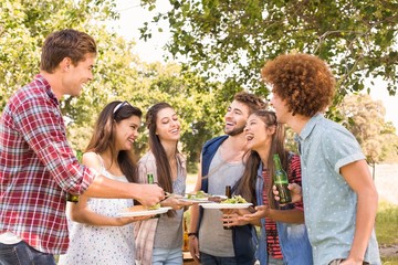 Happy friends in the park having barbecue